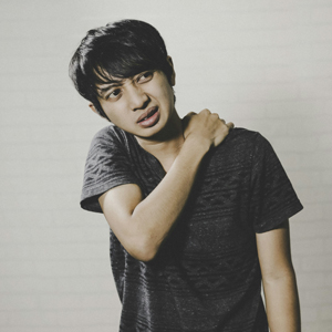 man rubbing his shoulder