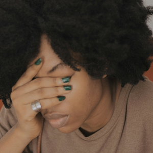Black woman with head in hands